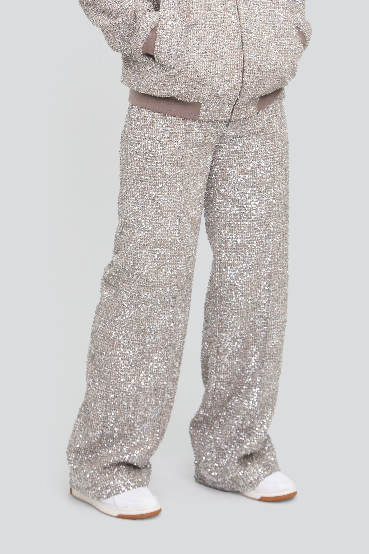Close up view of highly reflective silver metallic tweed fabric highlighting woven lurex fibers and crushed foil shards