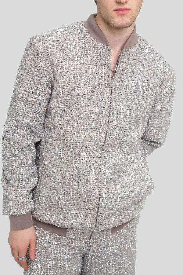 Close up view of highly reflective silver metallic tweed fabric highlighting woven lurex fibers and crushed foil shards