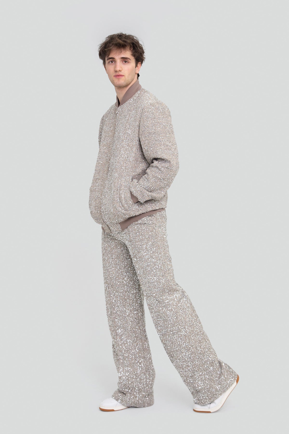 Model styling a luxury mens two piece silver star matching suit set with a structured metallic bomber jacket