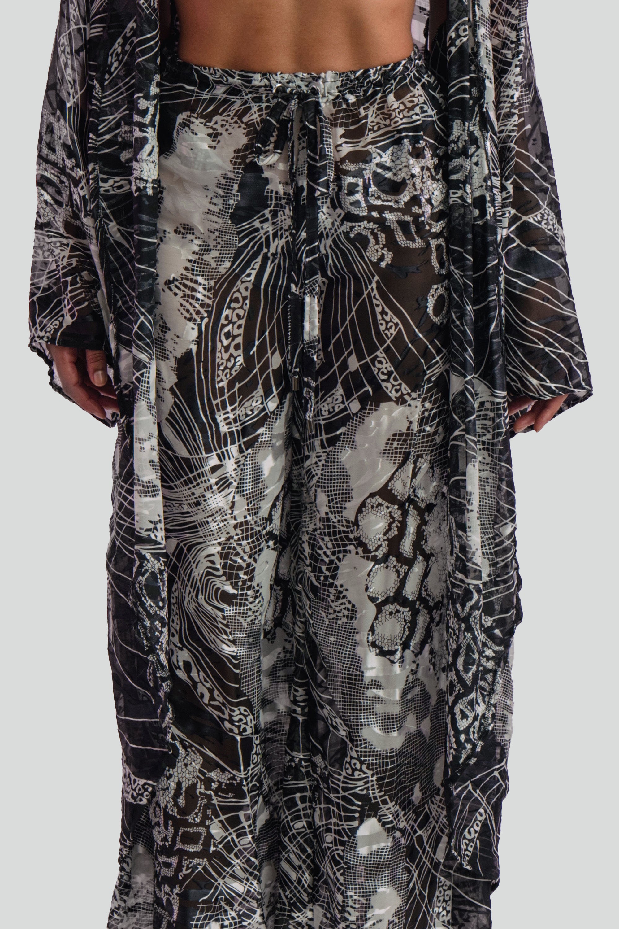 Close up view of a black and white patterned pants set on a plain background