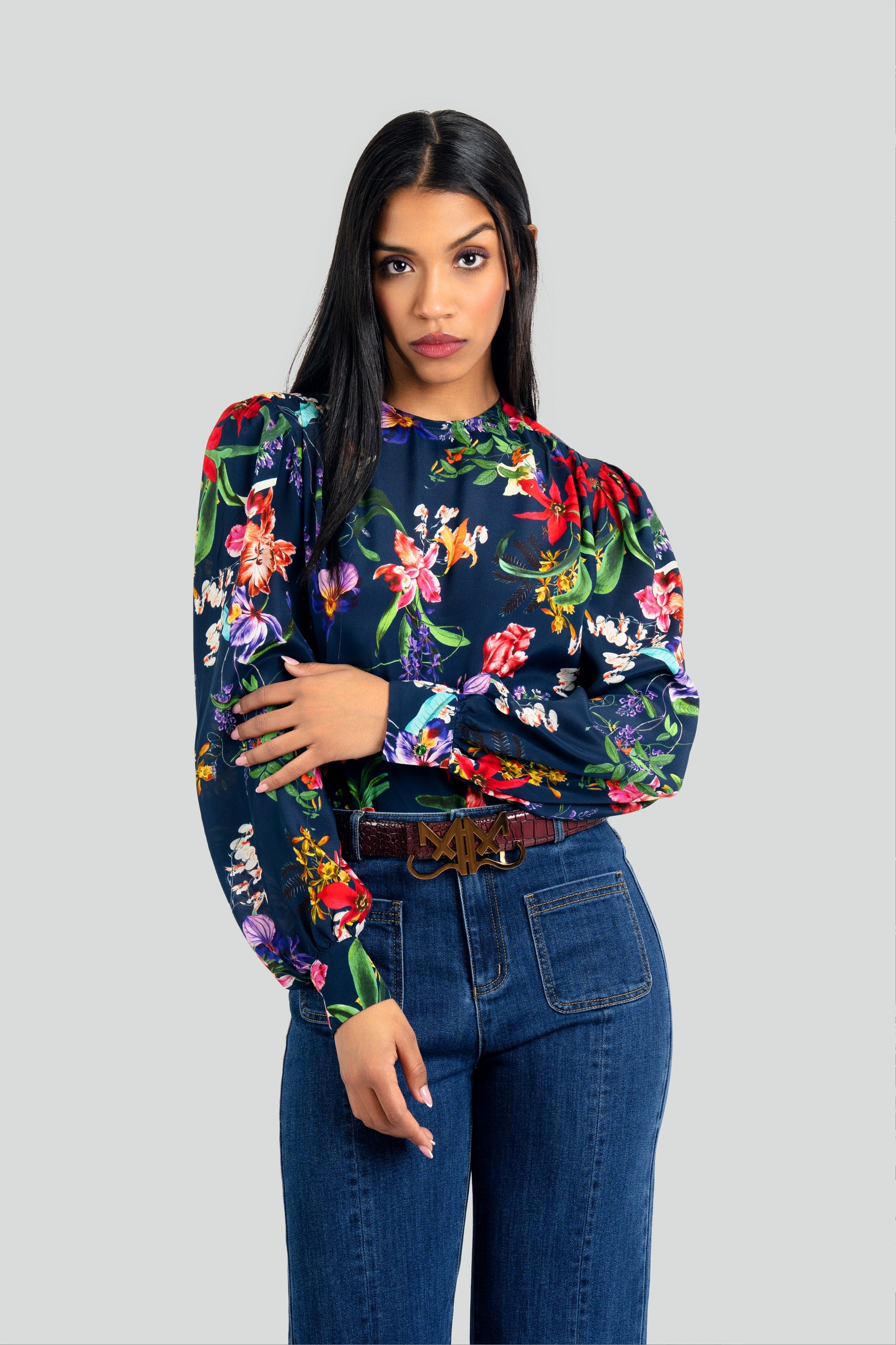 Woman wearing a vibrant floral print blouse by Maui X Lolita, showcasing a relaxed yet refined silhouette in a luxurious silk blend