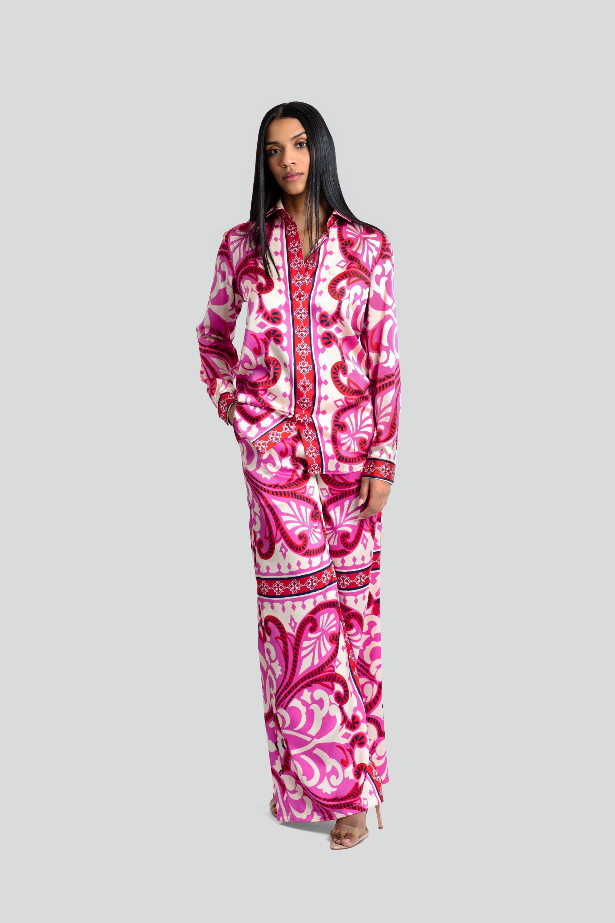 Model posing in a bold fuchsia and ivory two-piece satin matching pants set with tailored cuffs by Maui X Lolita