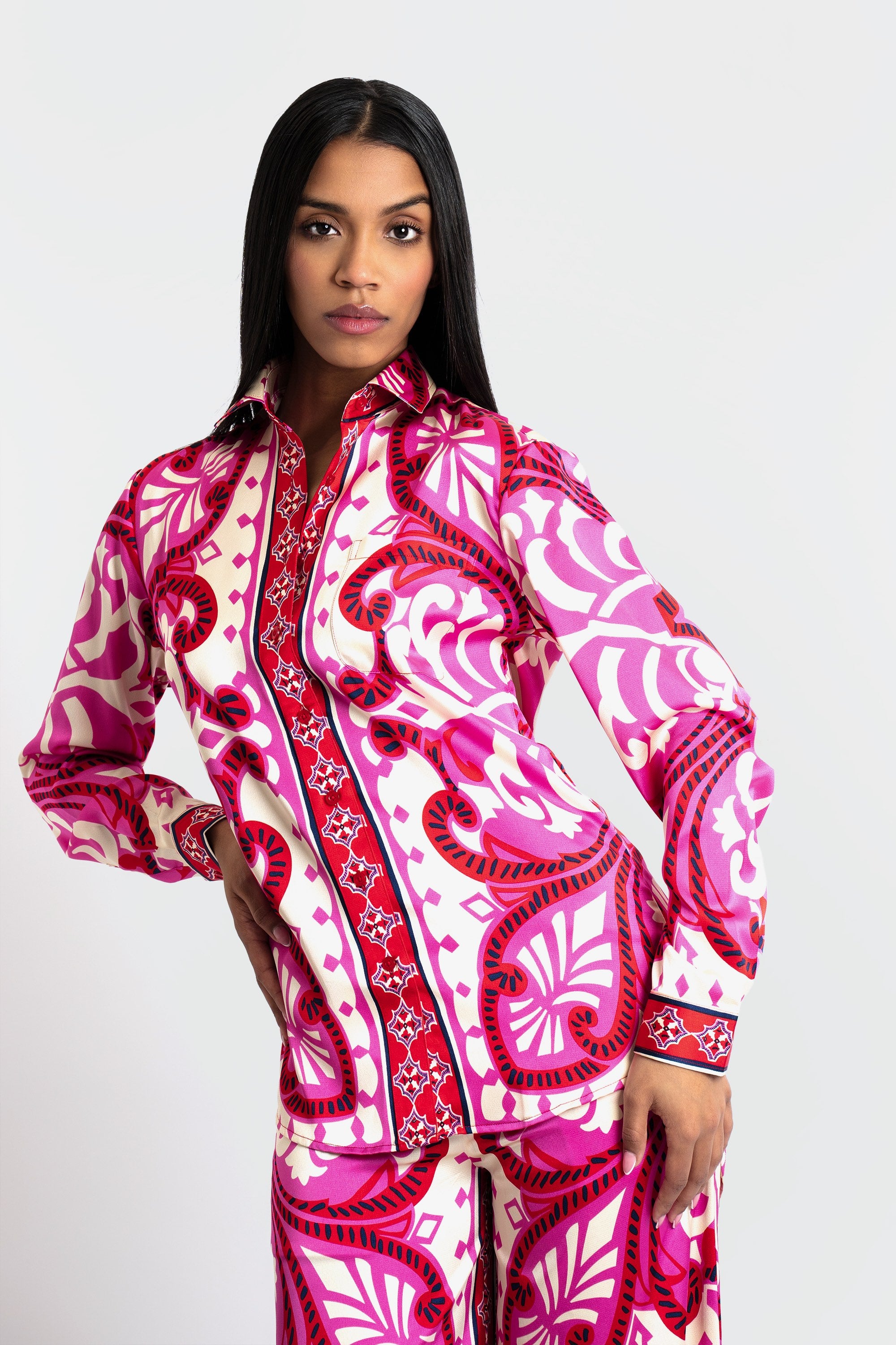 Woman wearing a pink and white patterned outfit on a white background
