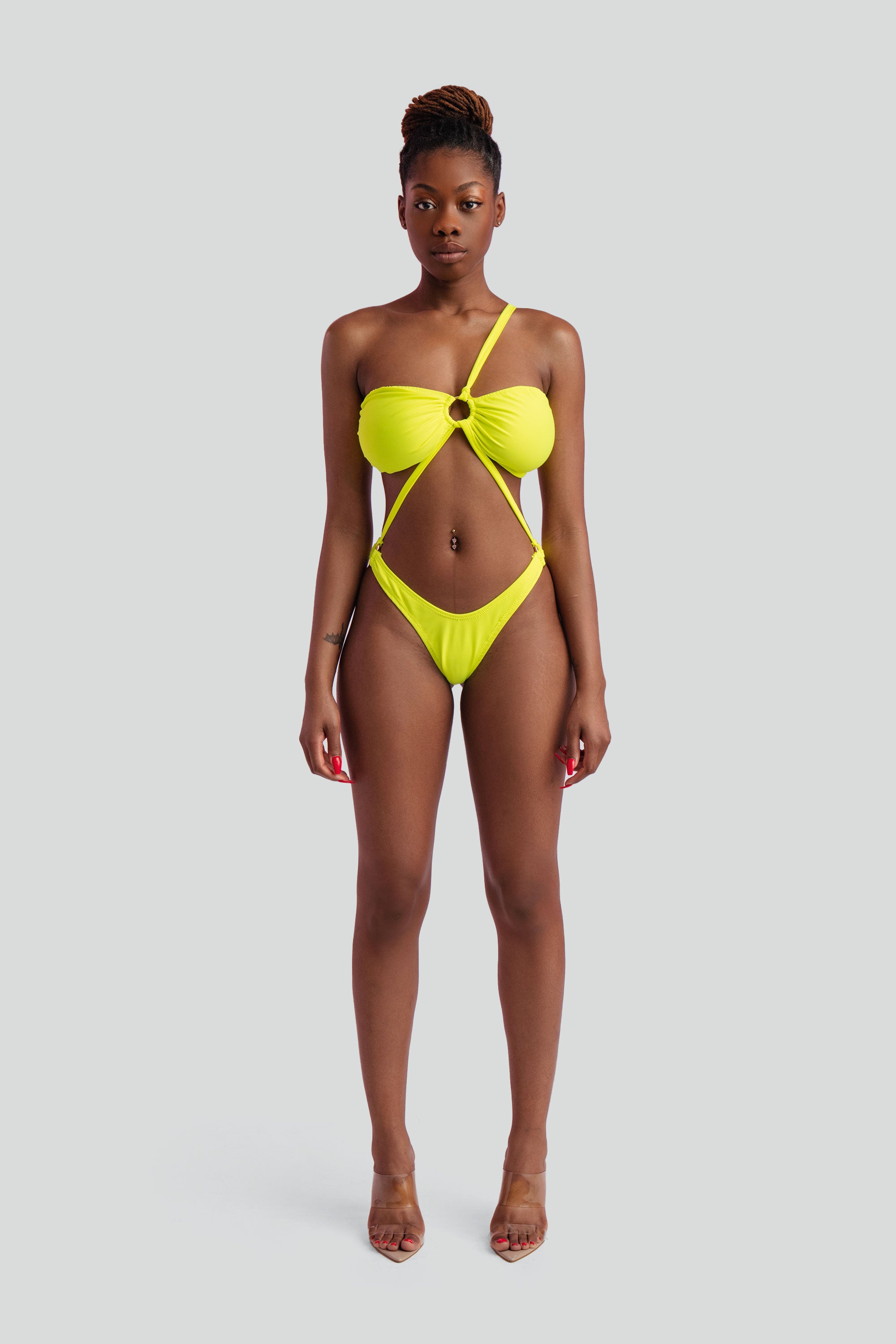 Woman wearing a neon yellow bikini against a white background