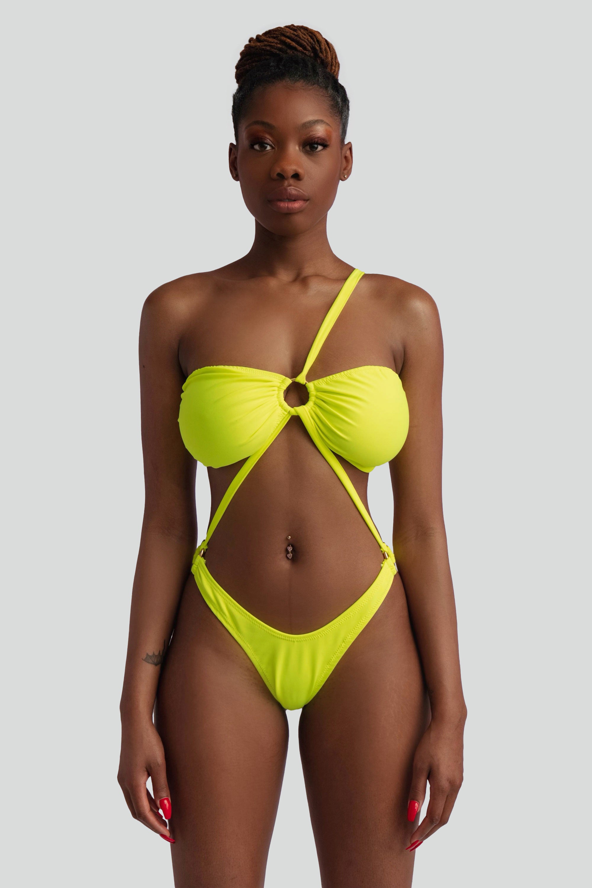 Woman wearing a neon yellow bikini against a white background