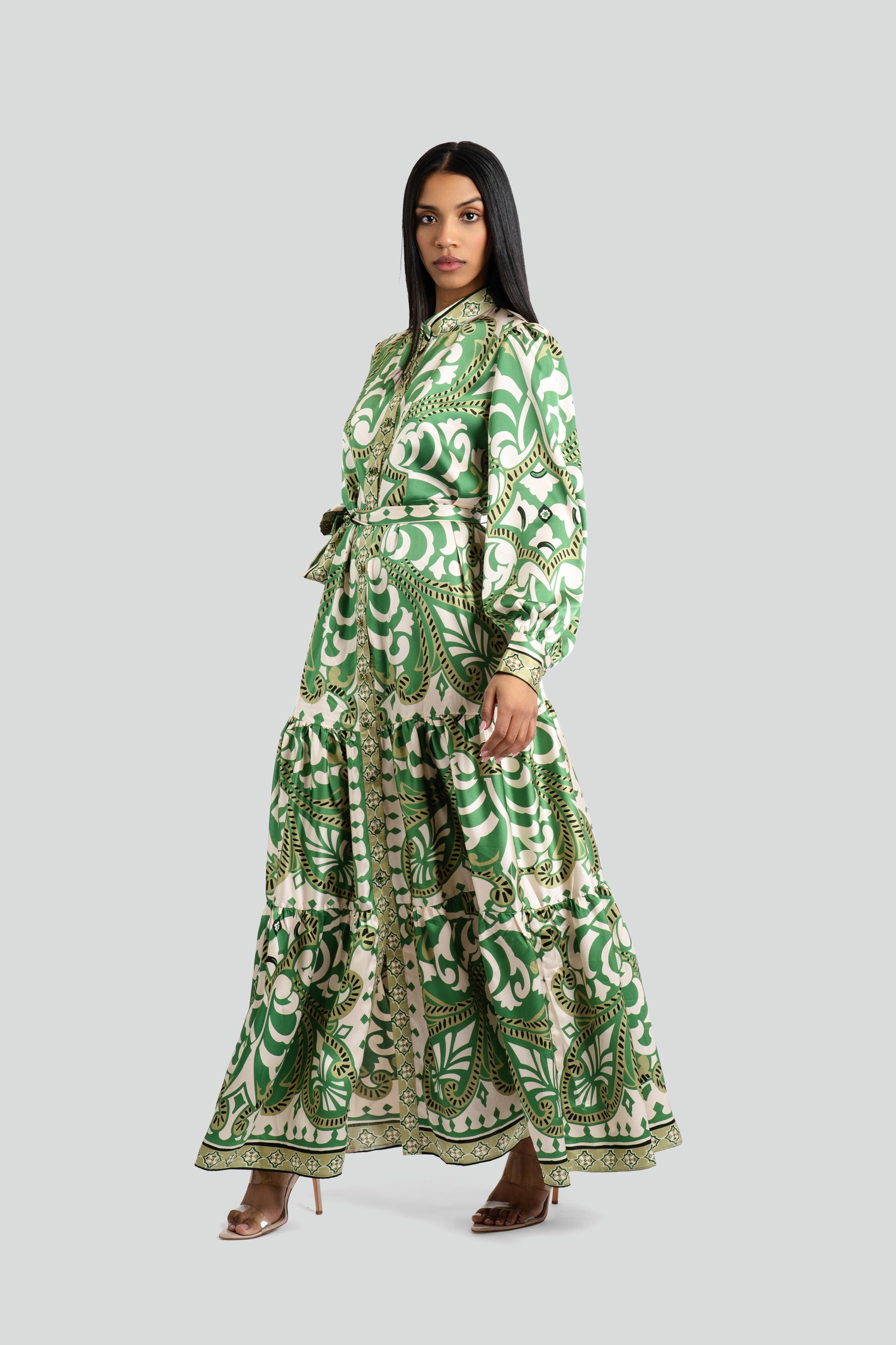 Woman wearing the emerald and cream maxi dress by Maui X Lolita, showcasing voluminous long sleeves and a fluid satin-finish skirt