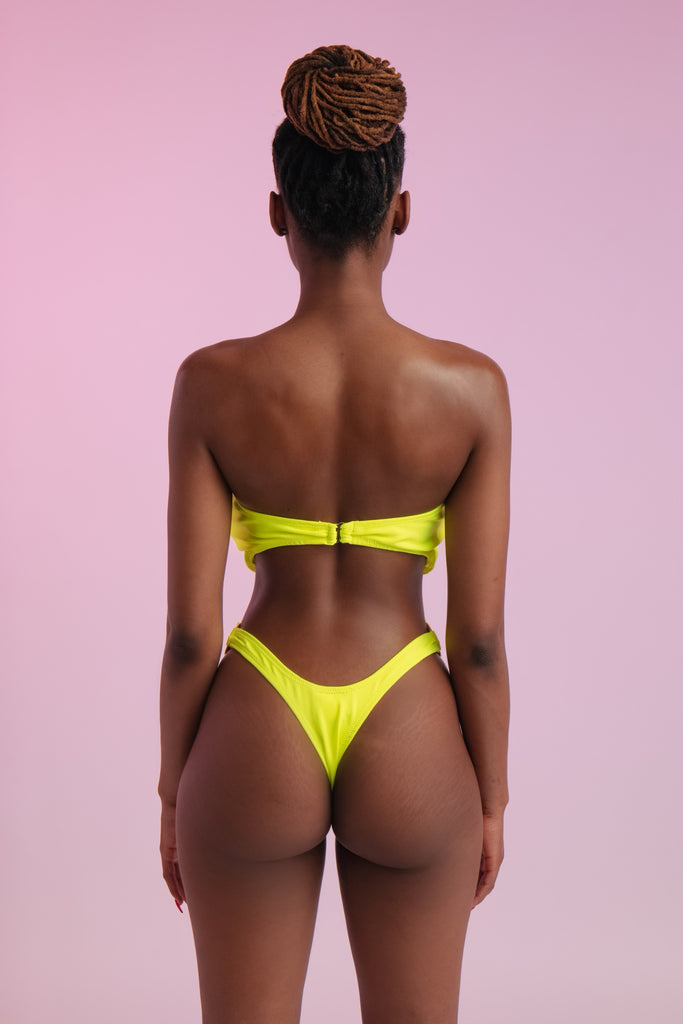 Back of model wearing a neon one piece swimsuit